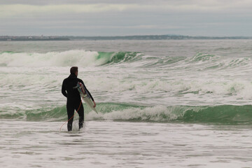 surfer entering the water