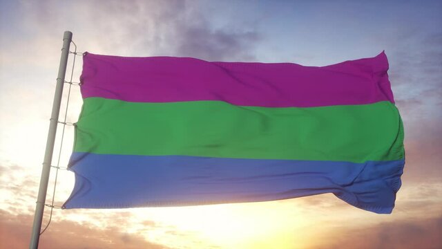 Polysexuality pride flag waving in the wind, sky and sun background