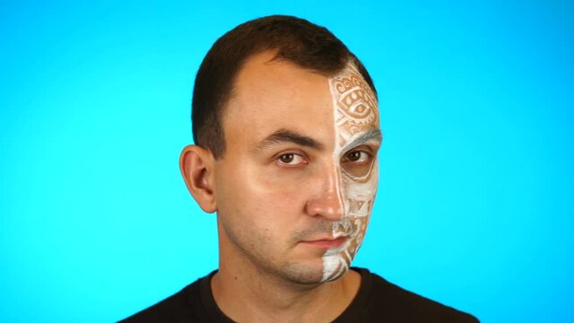 Man with painted face is saying no by shaking head against blue background