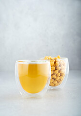 Chickpea aquafaba. Egg replacement. Vegan cooking concept. Chickpea, chickpea water in glass cup. On a gray background. Sustainable. Natural eco-friendly products. Copy space