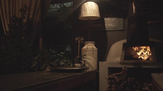 Cozy romantic restaurant with pizza over containing burning wood inside