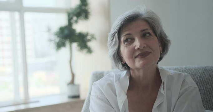 Cheerful senior grayish businesswoman laughing at her home office. Joyful competent middle-aged woman, gorgeous successful female mentor, elder ceo director close-up headshot portrait