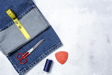 Handicraft, clothing repair. Ripped blue jeans sewing accessories