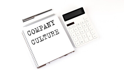 Notepad with text COMPANY CULTURE with calculator and pen. White background. Business concept