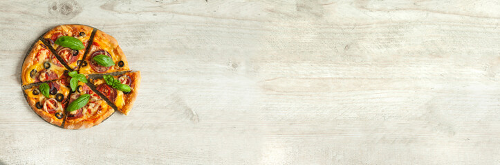 Pizza with salami, tomatoes and paprika on a gray wooden background. Top view with copy space. Banner