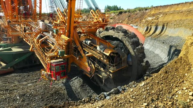 Bucket wheel excavator at work in coal mine. Mining industry from above. Open pit in Central Europe. Heavy industry before Green deal.