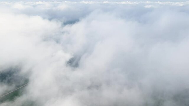Flying from top to bottom through the clouds. Concept of landing an aircraft. POV shot of a flight of gray dense haze
