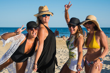 Group Of 4 Friends Enjoying A Sunny Day At The Beach. Happy And Smiling Women On Vacation. Vacation...