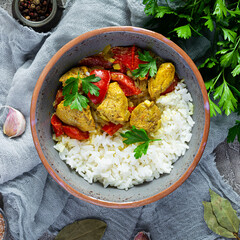 Spicy chicken curry with rice. Curry sauce with chicken and rice on gray background. Top view