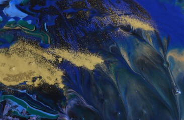 art photography of abstract marbleized effect background with black, gold and blue creative colors. Beautiful paint.