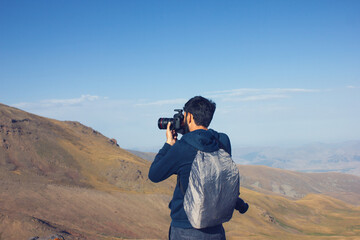 the photographer on the mountain takes a photo