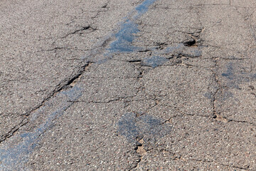 an asphalt road with a lot of holes and potholes