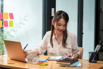 Beautiful smiling Asian businesswoman happy working at the office.