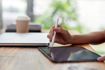 Close-up of a businesswoman hand using a stylus pen for drawing or writing using tablet  blank...