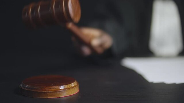 Judge hand tapping gavel three times in court, authority symbol, justice system