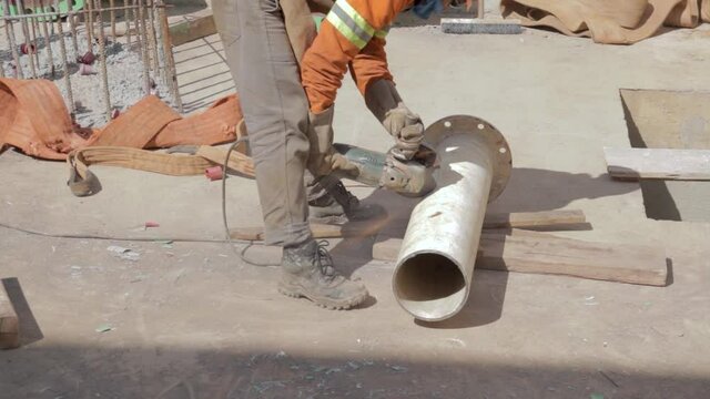 Homem serrando cano de a&ccedil;o 