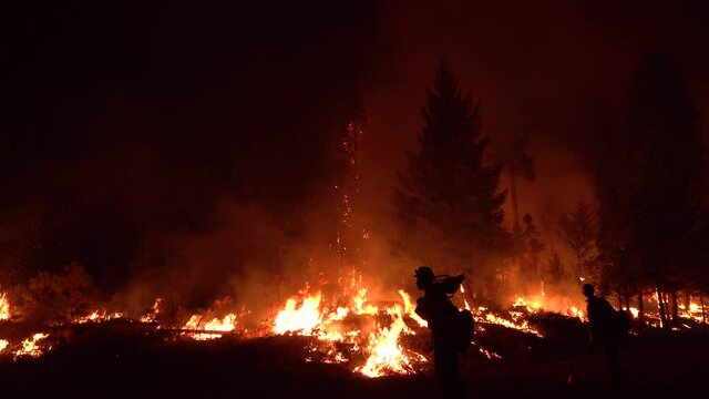 2021- Exhausted firefighters work hard at night to contain the disastrous Dixie Fire in Northern California.