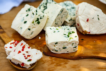 Slice of sheep cheese on a wooden background made from homemade fresh milk.