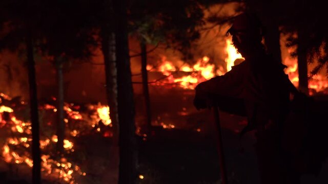 2021- Exhausted firefighters look on at night during the disastrous Dixie Fire in Northern California.