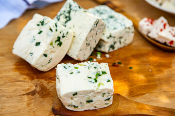 Slice of sheep cheese on a wooden background made from homemade fresh milk.
