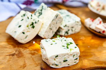 Slice of sheep cheese on a wooden background made from homemade fresh milk.