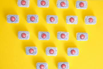 Dishwasher tablets on a yellow background top view