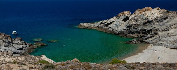 Dream beach with rugged rock cliff cove and azure blue water at the famous Nas bay on the hidden Greek Island of Ikaria.