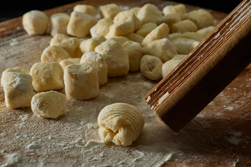 kneading gnocchi on wooden board with flour