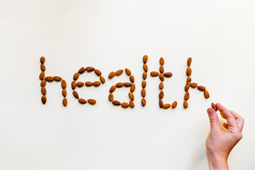 The word health laid out from almonds on a white background. Healthy snack.