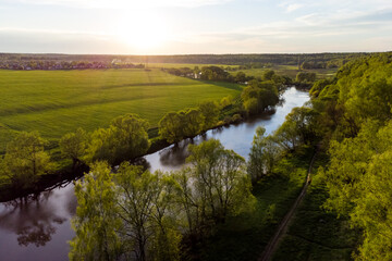 Fototapeta na wymiar Bird's eye view of the river valley and flood meadows, picturesque landscape at sunset