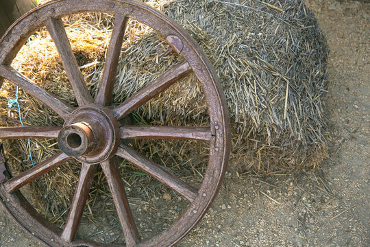 Old wooden wheel on the sheaf of hay