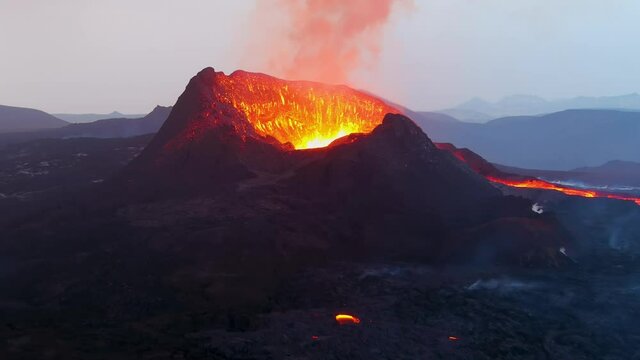 Spectacular aerial of lava firefall down inner cone of Fagradalsfjall volcano volcanic explosive eruption at night.