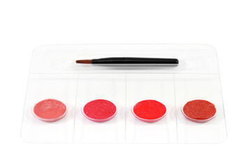 Four color lipstick samples with brush applicator isolated on white background