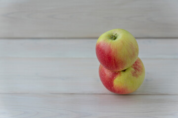 Two apples connected to each other on white wooden background, copy space. Ugly fruit concept
