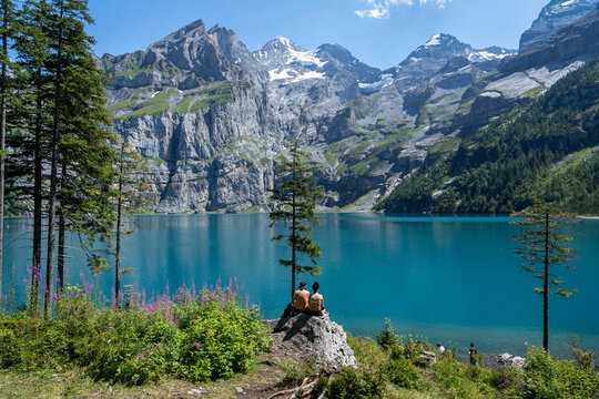 un couple face à un lac bleu entourés de montagnes