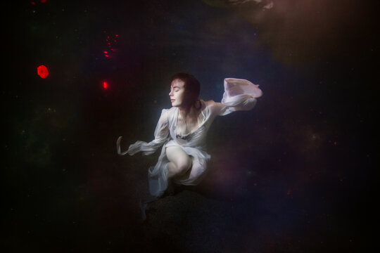 Abstract underwater painting of a girl dressed in a white dress underwater.