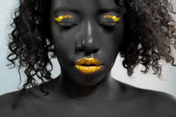 portrait of beautiful african woman with creative gold make up