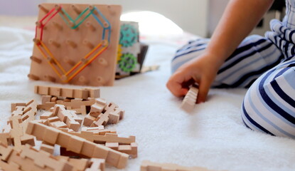 a little boy plays with wooden educational logic toys in the room selective focus.