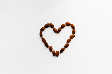 Almonds are laid out on a white background in the shape of a heart. Proper nutrition, healthy snack. Healthy heart.