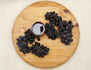 Bunches of natural organic farmer's black grapes on black plate background top view close up cup.
