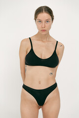 Obraz premium Beautiful girl without makeup with natural skin in lingerie on a white background