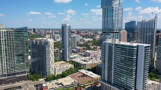 Beautiful aerial over downtown Austin, Texas reveals the State Capitol building in the distance.