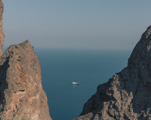 Rocks on the seashore, white yachts sailing