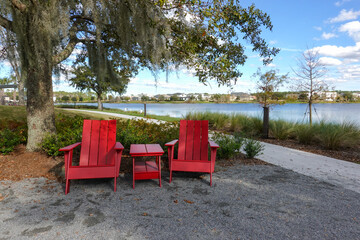 Two chairs sitting in a park by a lake in Laurete Park in Lake Nona, Orlando, FL on a beautiful...