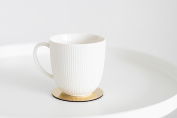 white mug on a white and gold table, minimalism
