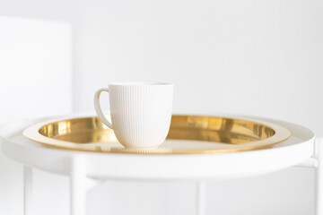 white mug on a white and gold table, minimalism
