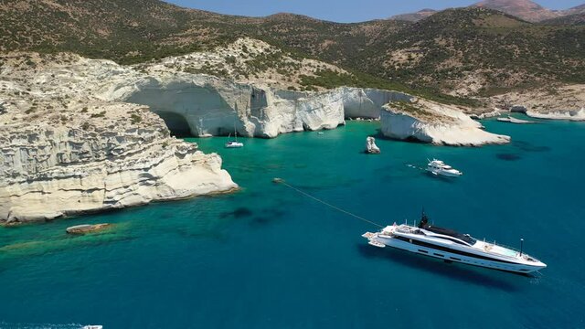 Arial drone video of Kleftiko a beautiful scenic white volcanic rock formation bay visited by sail boats and yachts with turquoise crystal clear sea and caves, Sea Meteora of Greece, Milos island