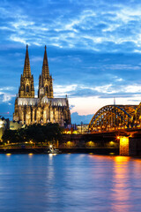 Cologne Cathedral city skyline and Hohenzollern bridge with Rhine river in Germany at twilight portrait format