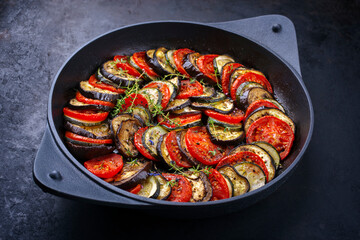 Modern style traditional French ratatouille with tomatoes, eggplant and zucchini served as close-up in a rustic cast-iron skillet