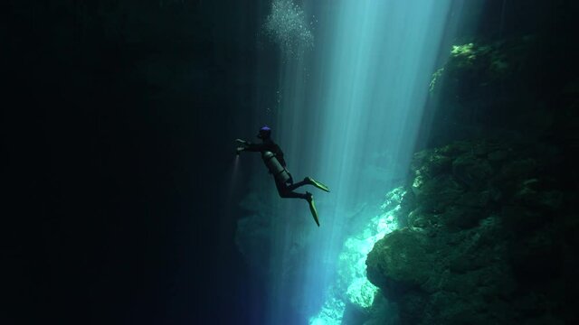 2021 - A diver swims out of a beam of light into darkness off the coast of Mexico's Yucatan peninsula.
